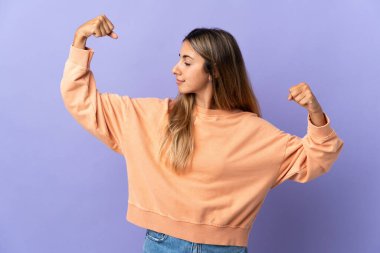 Tecrit edilmiş mor arka planı olan genç İspanyol kadın güçlü bir jest yapıyor.
