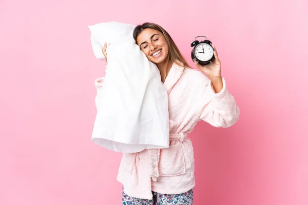 Молодая Латиноамериканка Изолированном Розовом Фоне Пижаме Часами Подушкой Счастливым Выражением — стоковое фото