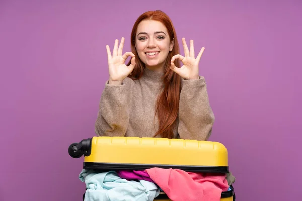 Podróżnik Nastolatka Dziewczyna Walizką Pełną Ubrań Pokazując Znak Palcami — Zdjęcie stockowe