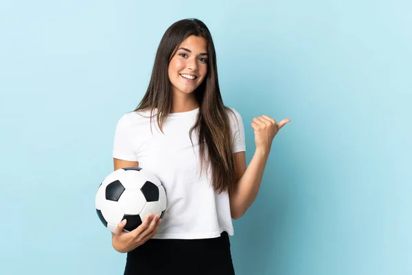 Młoda Piłkarz Brazylijski Dziewczyna Izolowane Niebieskim Tle Wskazując Stronie Przedstawić — Zdjęcie stockowe