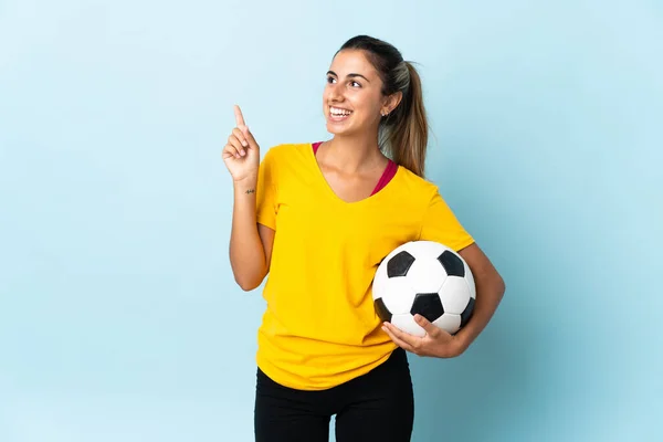 Młoda Latynoska Kobieta Grająca Piłkę Nożną Odludziu Niebieskim Tle Wskazując — Zdjęcie stockowe