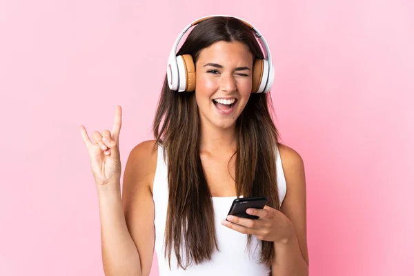 Νεαρή Βραζιλιάνα Κοπέλα Απομονωμένη Ροζ Φόντο Ακούγοντας Μουσική Μια Κινητή — Φωτογραφία Αρχείου