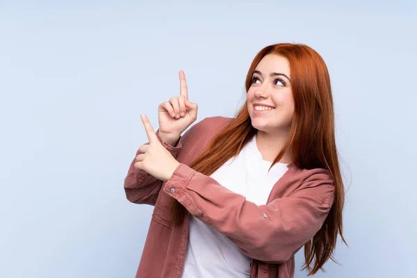 Redhead Teenager Dívka Přes Izolované Modré Pozadí Ukazuje Ukazováčkem Skvělý — Stock fotografie