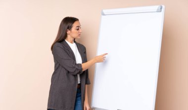 Beyaz tahtada sunum yapan genç bir kadın beyaz tahtada sunum yapıyor.