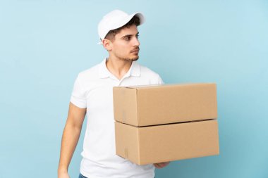 Teslimat yapan beyaz adam mavi arka planda izole edilmiş.