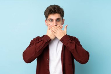 Kafkasyalı genç adam arka planı izole ederek ağzı elleriyle kapatıyor.