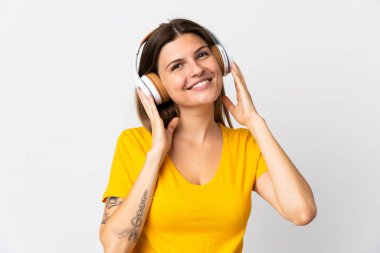 Genç Slovak kadın beyaz arka planda izole edilmiş müzik dinliyor.