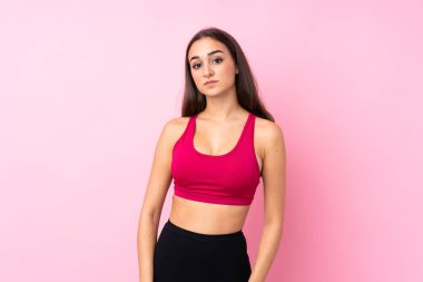 Soyutlanmış pembe arka planda genç bir kız mutlu ve gülümsüyor.