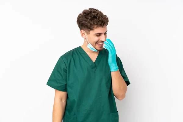 身穿绿色制服的外科医生被隔离在孤独的白色背景下 面带微笑 — 图库照片