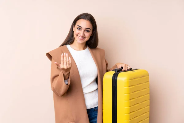 Traveler woman with suitcase inviting to come with hand. Happy that you came