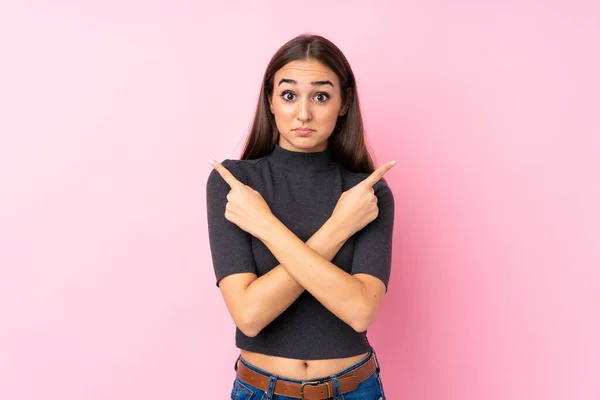 Jong Meisje Geïsoleerde Roze Achtergrond Wijzend Naar Lateralen Met Twijfels — Stockfoto