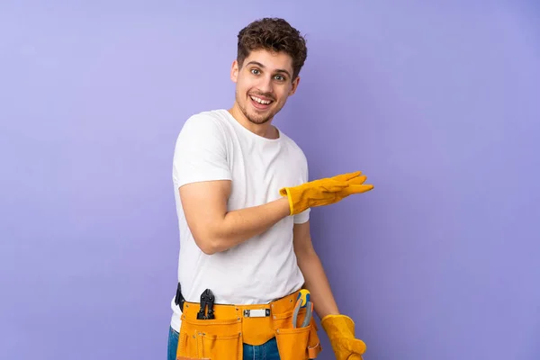 Jovem Eletricista Homem Sobre Isolado Fundo Roxo Estendendo Mãos Para — Fotografia de Stock