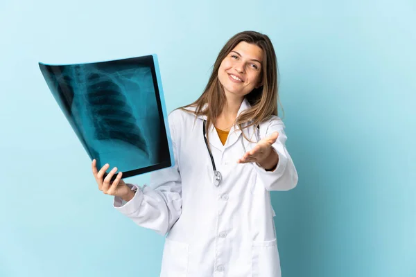 Jovem Médico Mulher Segurando Radiografia Sobre Fundo Isolado Apertando Mãos — Fotografia de Stock