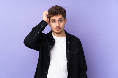 Kafkasyalı bir adam mor arka planda, hayal kırıklığıyla izole edilmiş ve anlamamış.