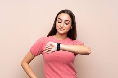 Kol saatine bakarak izole edilmiş genç bir kadın.