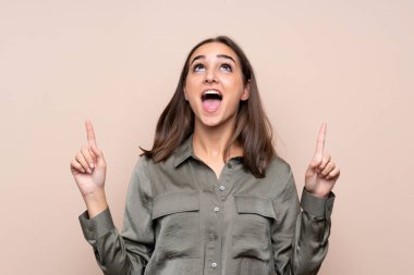 Izole arka plan üzerinde genç kız şaşırttı ve işaret