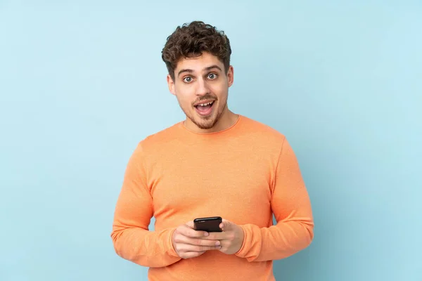 Hombre Caucásico Aislado Sobre Fondo Azul Sorprendido Enviando Mensaje —  Fotos de Stock