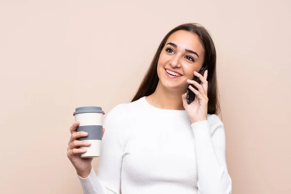 Giovane Donna Sfondo Isolato Possesso Caffè Portare Cellulare — Foto Stock