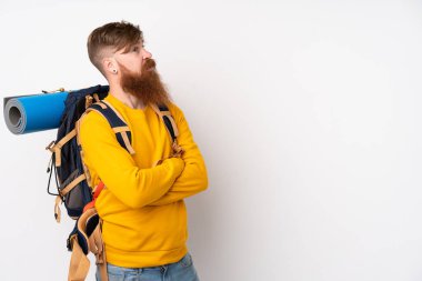 Genç dağcı, izole edilmiş beyaz arka planda büyük bir sırt çantası ile gülüyor.