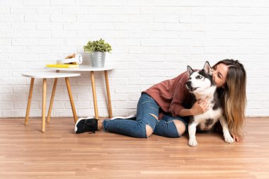 Genç ve güzel bir kadın. İri köpeğiyle içeride yerde oturuyor.