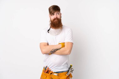 Kızıl saçlı elektrikçi, uzun sakallı, izole edilmiş beyaz arka planda bir fikir düşünüyor.