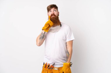 Kızıl saçlı elektrikçi, uzun sakallı, izole edilmiş beyaz arka planda bir fikir düşünüyor.