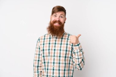 Uzun sakallı, soyutlanmış beyaz arkaplanı olan kızıl saçlı bir adam bir ürün sunmak için kenarı işaret ediyor.