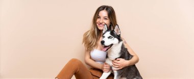 Genç ve güzel bir kadın. İri köpeğiyle içeride yerde oturuyor.