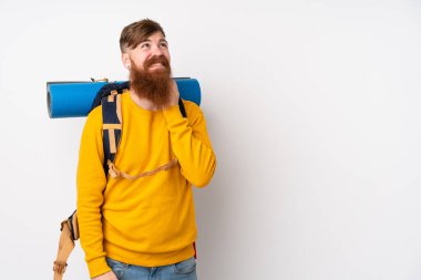 İzole edilmiş beyaz bir arka plan üzerine büyük bir sırt çantası olan genç dağcı bir fikir düşünüyor.
