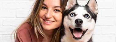 Genç ve güzel bir kadın. İri köpeğiyle içeride yerde oturuyor.