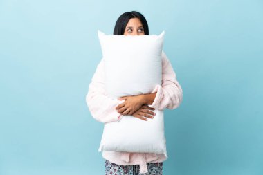 Pijamalı genç bir kadın pijamalı ve elinde yastıkla izole edilmiş bir geçmişi var.