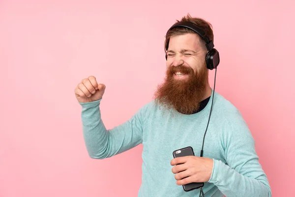 Homem Ruivo Com Longa Barba Sobre Fundo Rosa Isolado Ouvindo — Fotografia de Stock