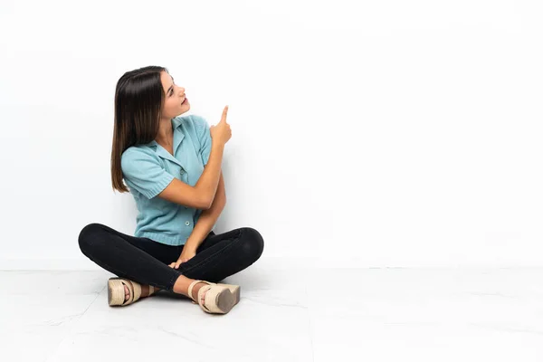 Chica Adolescente Sentada Suelo Apuntando Hacia Atrás Con Dedo Índice — Foto de Stock