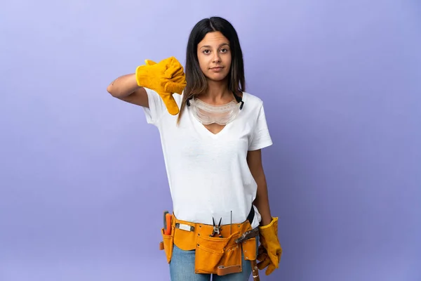 Junge Elektrikerin Isoliert Auf Lila Hintergrund Zeigt Daumen Nach Unten — Stockfoto