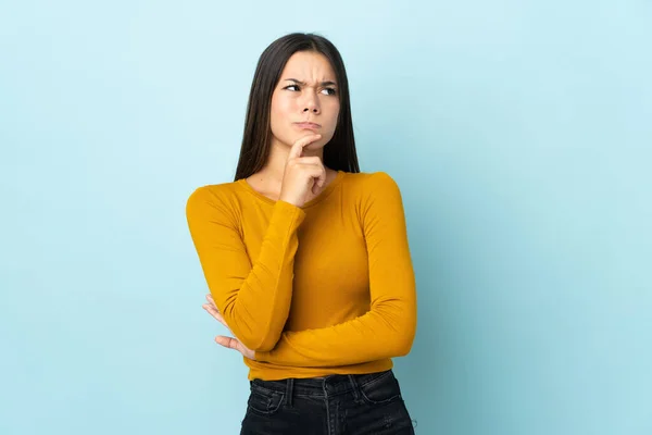 Adolescente Chica Aislada Sobre Fondo Azul Teniendo Dudas Pensando —  Fotos de Stock