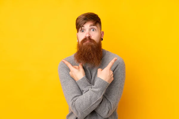 Redhead Man Long Beard Isolated Yellow Background Pointing Laterals Having — Stock Photo, Image