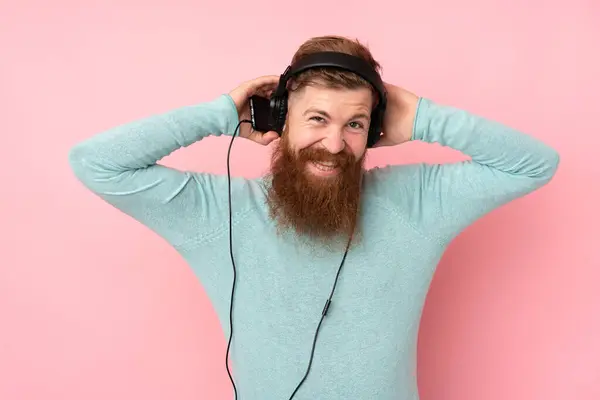 Homem Ruivo Com Barba Longa Sobre Fundo Rosa Isolado Ouvindo — Fotografia de Stock