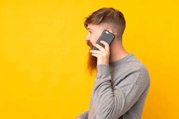 Рыжий Длинной Бородой Изолированном Желтом Фоне Ведет Разговор Кем Мобильного — стоковое фото