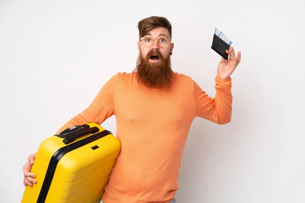長いです髭を生やした男上の隔離された白い背景で休暇でスーツケースとパスポートと驚き — ストック写真