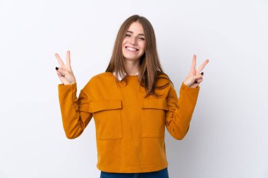 İzole edilmiş beyaz arka planda genç bir kadın iki eliyle zafer işareti gösteriyor.