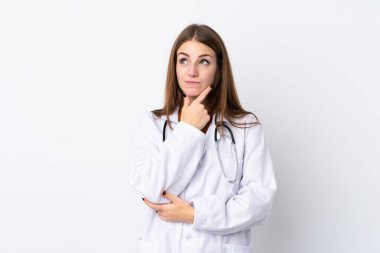 Tecrit edilmiş genç bir kadın doktor önlüğü giyiyor ve düşünüyor.