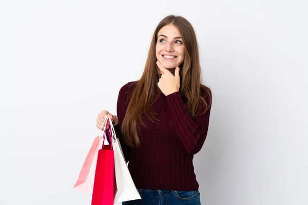 Jonge Vrouw Geïsoleerde Witte Achtergrond Met Winkeltassen Denken — Stockfoto