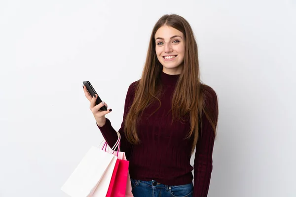 Mujer Joven Sobre Fondo Blanco Aislado Sosteniendo Bolsas Compras Escribiendo — Foto de Stock