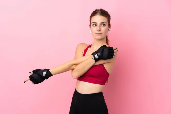 Joven Deporte Mujer Sobre Aislado Rosa Fondo Estiramiento Brazo —  Fotos de Stock