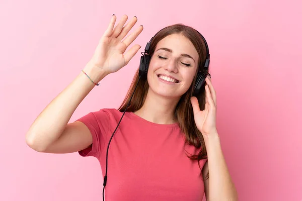 Νεαρή Γυναίκα Πάνω Από Απομονωμένο Ροζ Φόντο Ακούγοντας Μουσική Και — Φωτογραφία Αρχείου