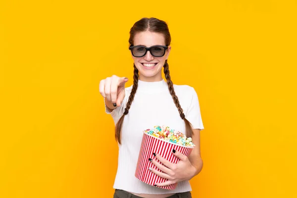 Młoda Kobieta Odizolowanym Żółtym Tle Okularami Trzymając Duże Wiadro Popcornów — Zdjęcie stockowe