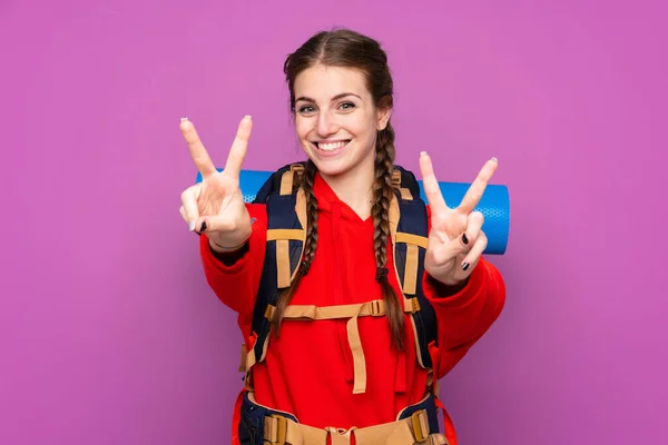 Νεαρό Κορίτσι Ορειβάτης Ένα Μεγάλο Σακίδιο Απομονωμένο Μωβ Φόντο Χαμογελώντας — Φωτογραφία Αρχείου