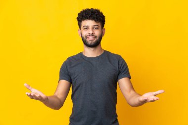 Genç Faslı adamın sarı arka planda izole edilmiş şüpheleri var.