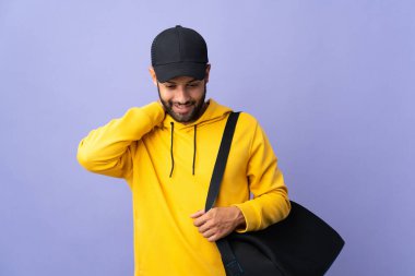 Spor çantalı genç Faslı adam, mor arka plana izole edilmiş gülüyor.