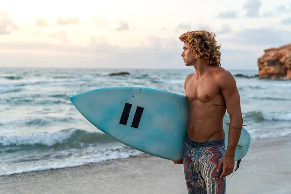 Young caucasian man get up early to  doing surf at sunrise